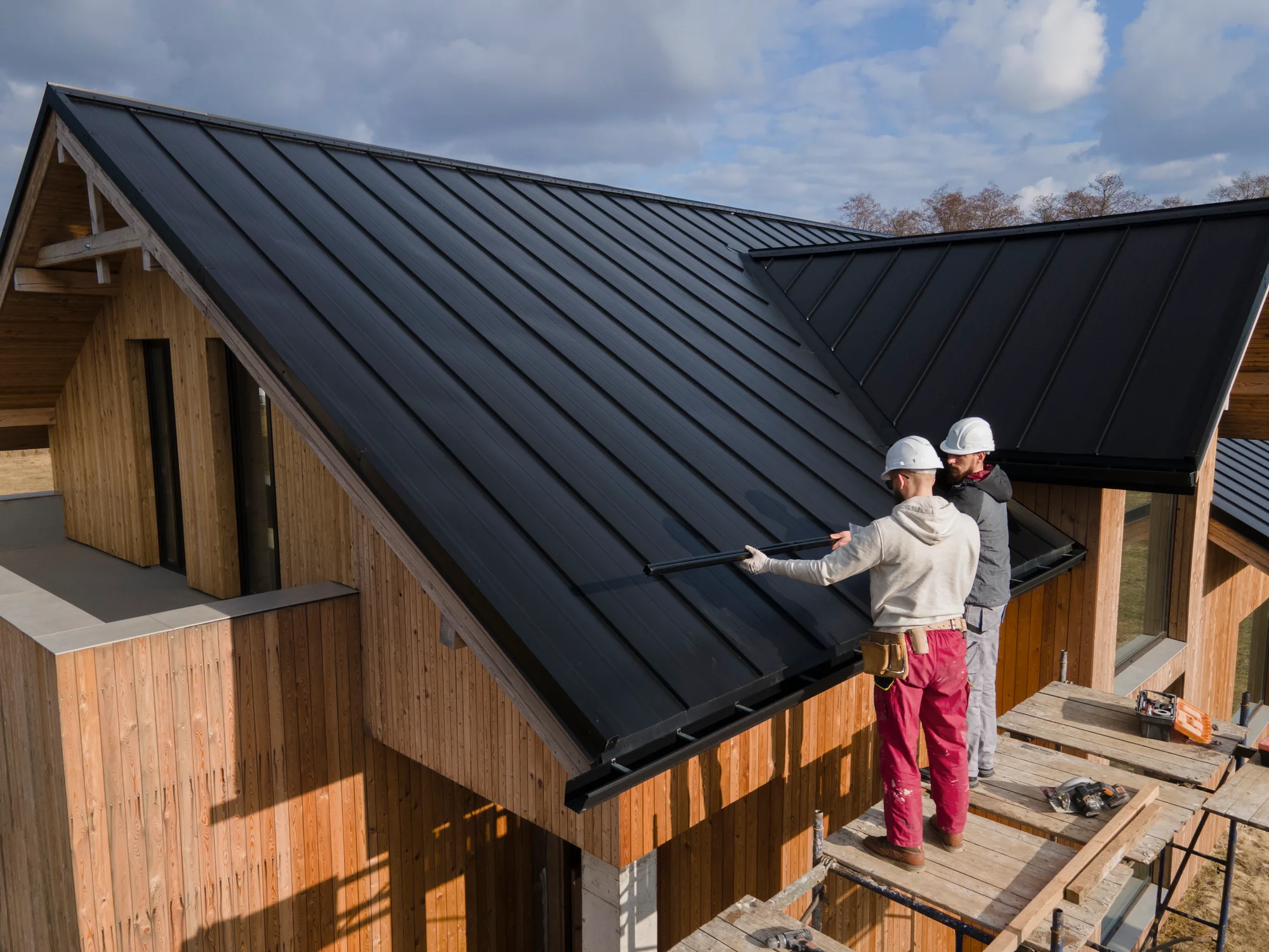 Roofers working on a standing-seam metal roof